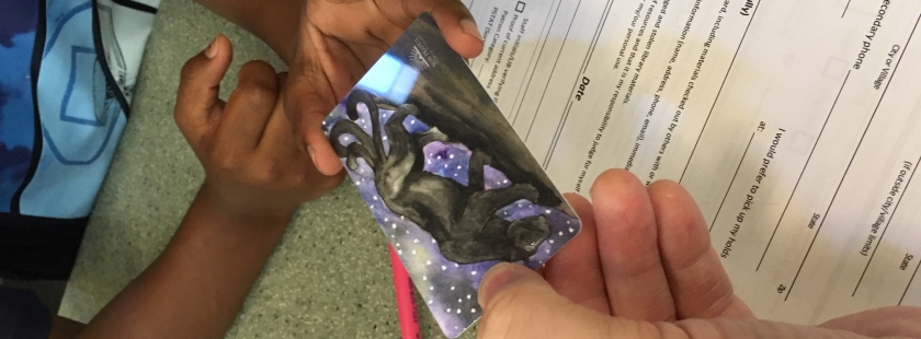 a child receiving the last library card with a cool panther image on it