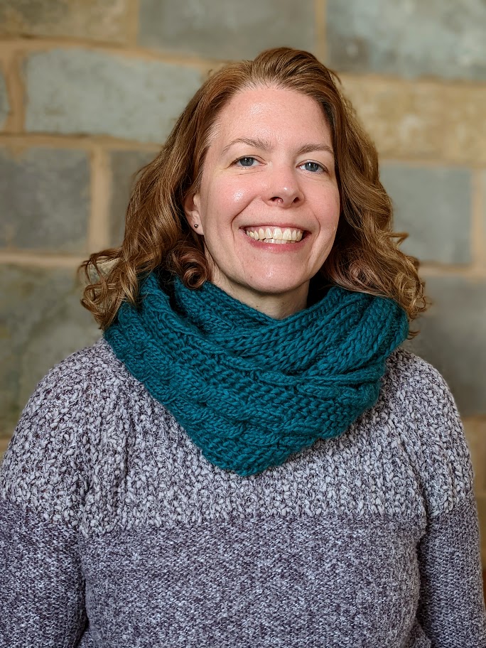 "Photo of Lynn Montague. Brown hair, fair skin, teal scarf, purple sweater."