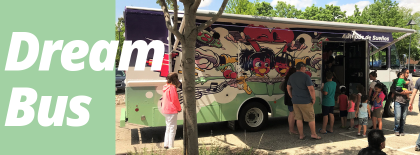 a bookmobile parked in the library parking lot with a line of people waiting to get inside