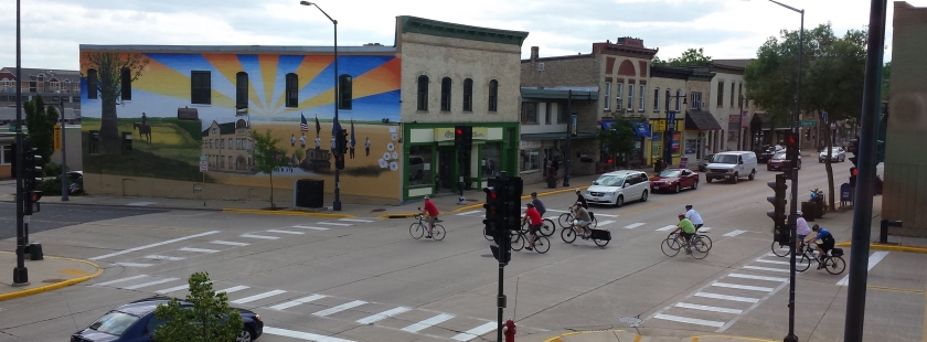 main street crossing with bikes and a mural