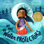 This image shows the cover for the book "We Are Water Protectors" by Carole Lindstrom. It shows a young Native Girl holding a feather and surrounded by water and in front of a moon. The background shows silhouettes of individuals holding hands.